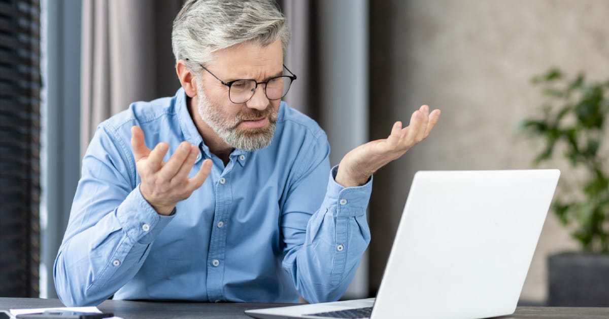 A man surprised by Social Security misconceptions he is reading on a laptop